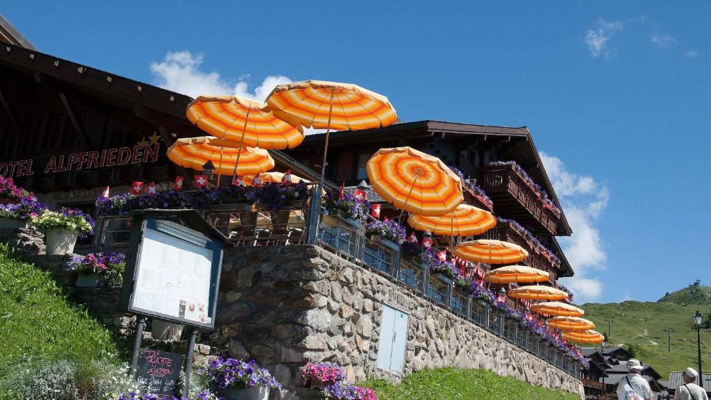 a group of orange umbrellas on top of a building at Hotel Alpfrieden in Bettmeralp