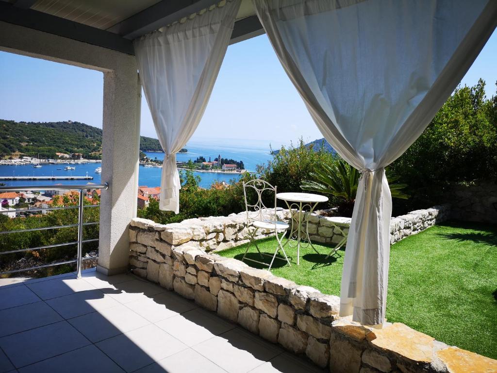 a patio with a stone wall and a table and chairs at Luxury apartment Prestige Villa Bellevue in Vis