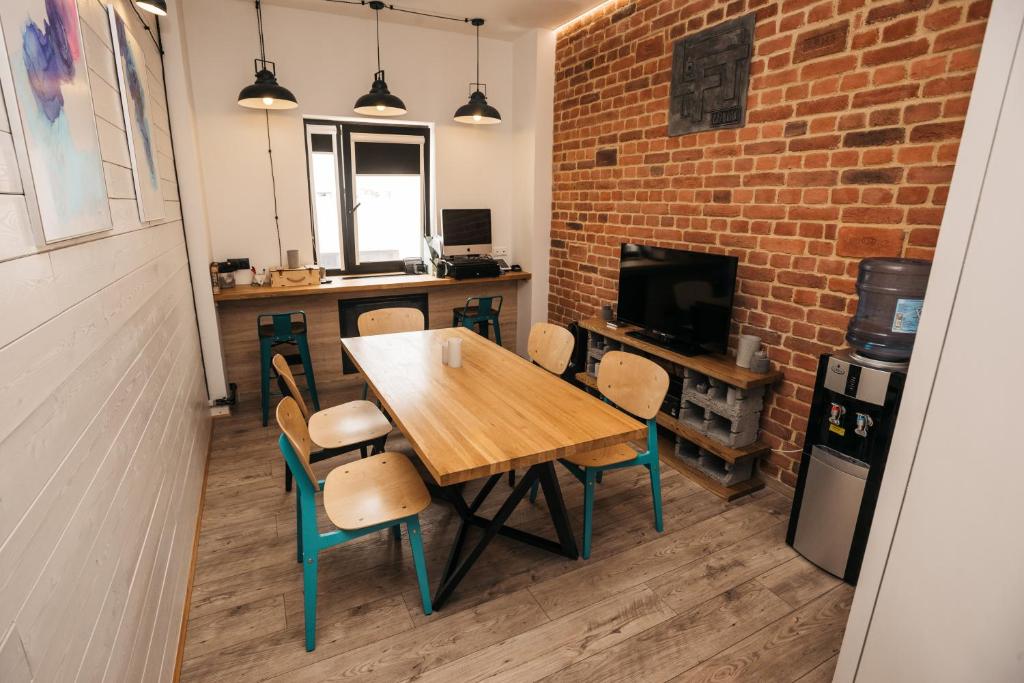 a dining room with a table and chairs and a brick wall at Хостел LOFT in Belgorod