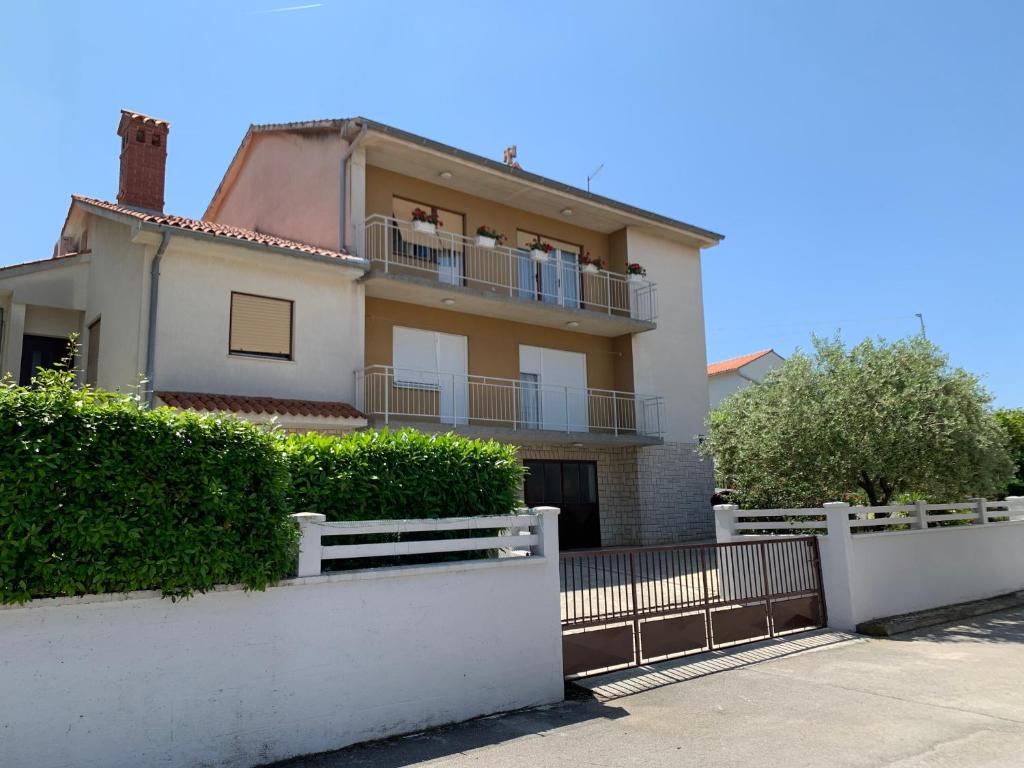 a house with a white fence in front of it at Apartment Bilić in Pula