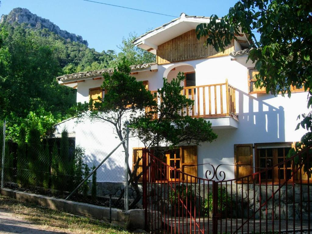 Casa blanca con balcón y valla en Casa Rural Los Jamones, en Arroyo Frío