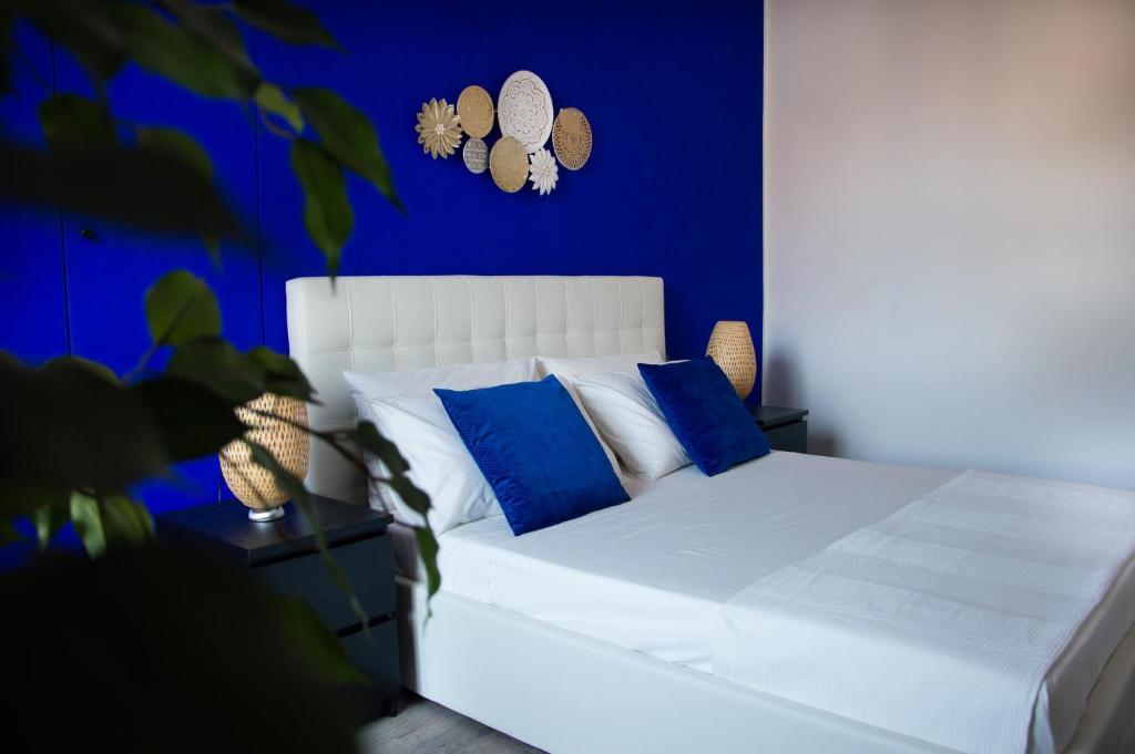 um quarto azul com uma cama branca com almofadas azuis em AMA Casa em Pisa
