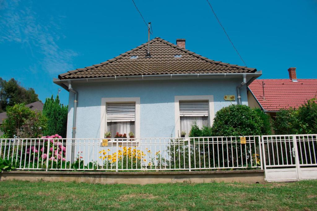 a white fence in front of a house at Anna Vendégház in Harkány