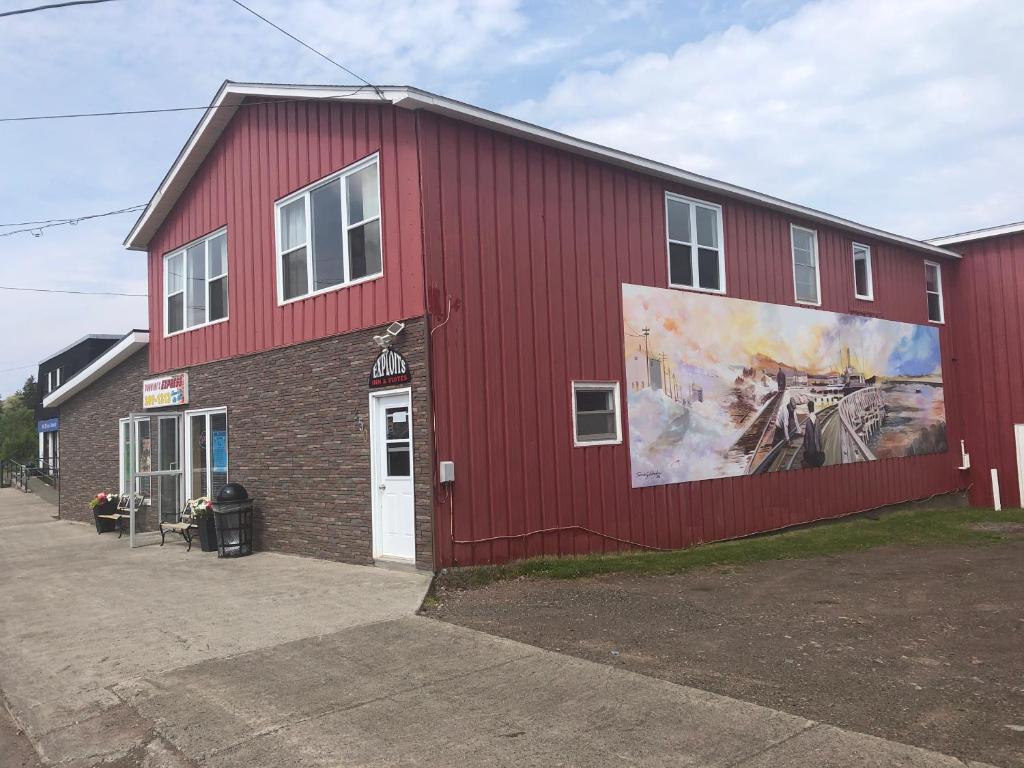 BotwoodExploits Inn and Suites的一面有画的红色建筑