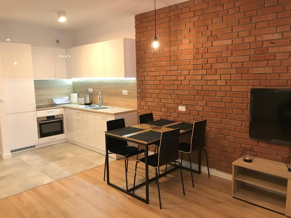 a kitchen with a table and chairs and a brick wall at Apart Prestige Ząbkowska Old Town in Warsaw