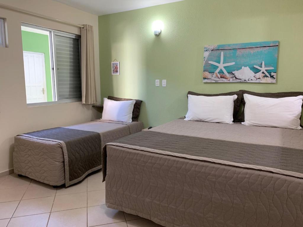 a bedroom with two beds and a window at Pousada Mar Do Leste in Florianópolis