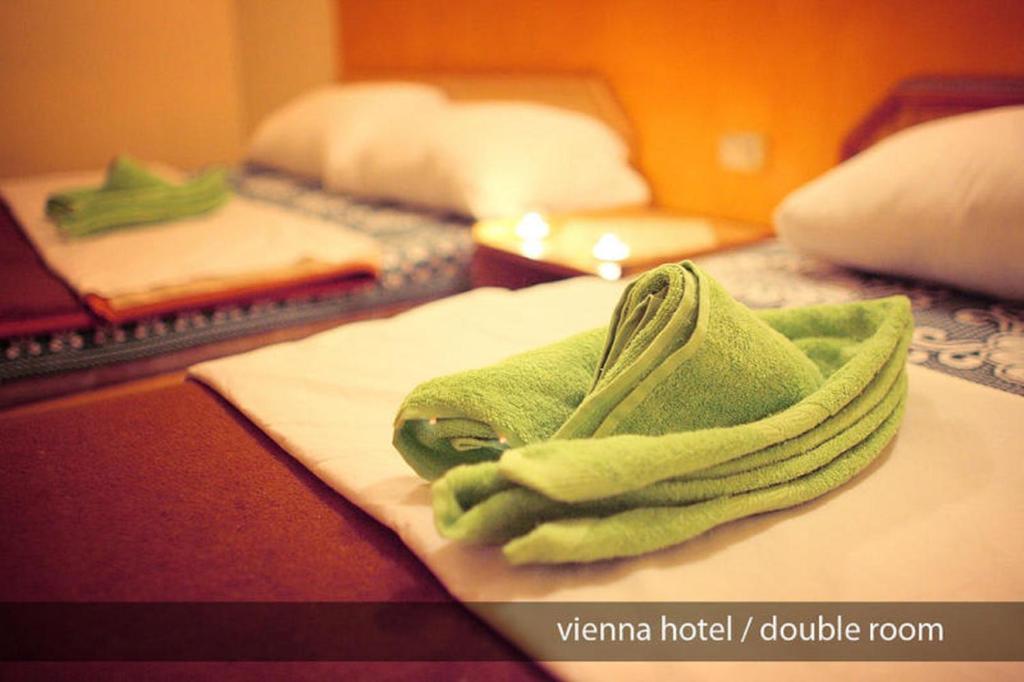 a green towel on a bed in a hotel room at Hostel Vienna in Cairo