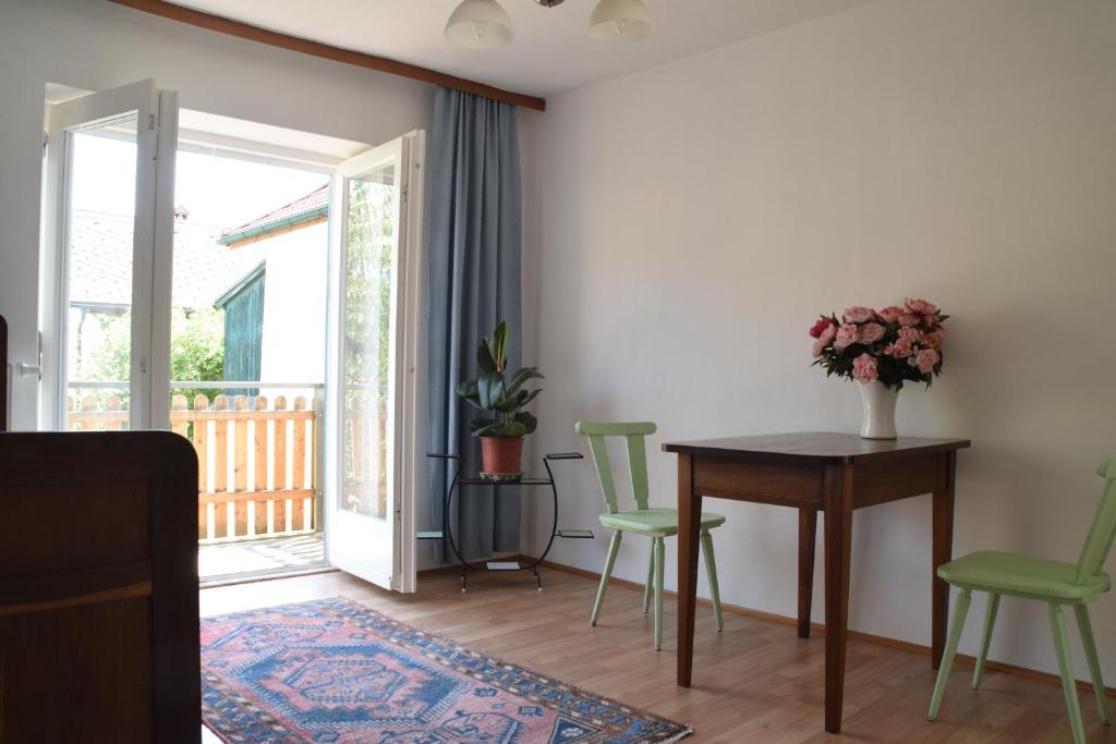 een woonkamer met een tafel en groene stoelen bij Vintage-Ferienwohnung für 2 in Schörfling