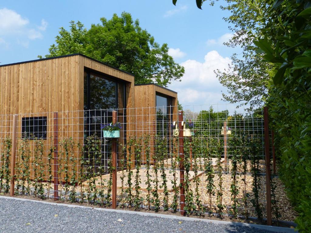 einen Zaun vor einem Gebäude mit Pflanzen in der Unterkunft Trendy Tiny Houses Bovenweg in Rhenen