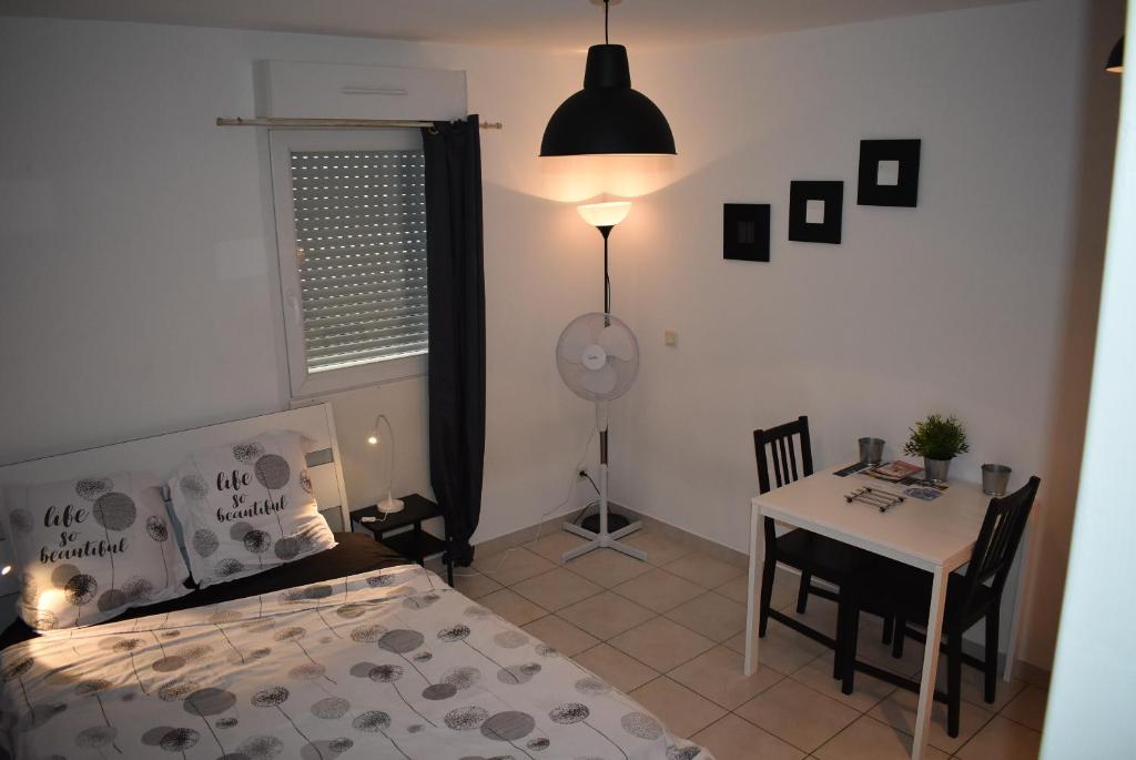 a bedroom with a bed and a table and a desk at LE 18 Dhuoda in Nîmes