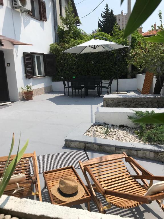 a patio with chairs and a table and an umbrella at Kuća za odmor City Oasis in Rijeka