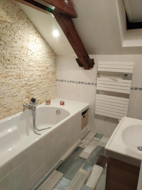 une salle de bain avec une baignoire et un lavabo dans l'établissement Duplex cozy, à Montigny-lès-Metz