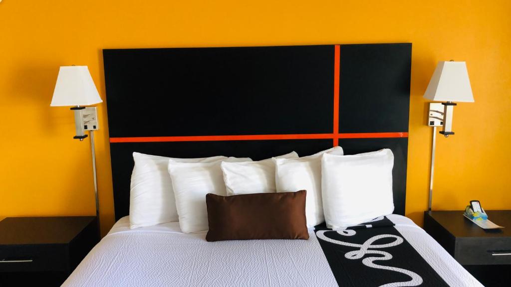 a bedroom with a bed with white pillows and two lamps at Chaparral Motor Inn in Burlington