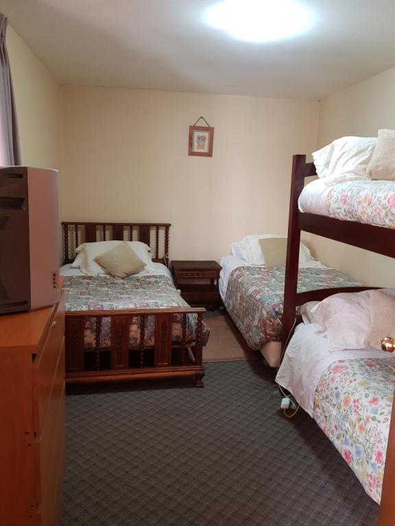 Pokój z 2 łóżkami piętrowymi i telewizorem w obiekcie Hospedaje klickmann w mieście Temuco