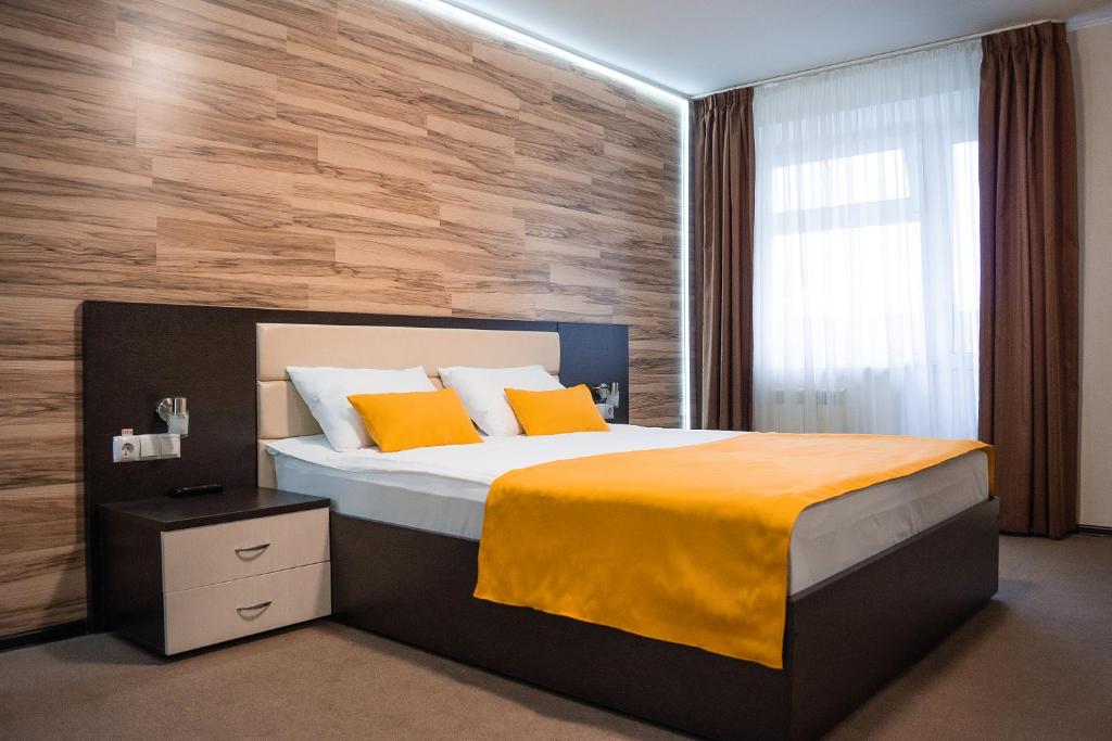 a bedroom with a large bed and a wooden wall at Hotel People in Cheboksary