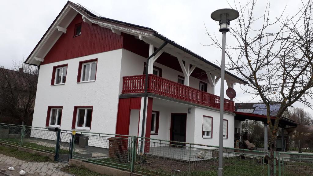 Casa roja y blanca con balcón rojo en Gästehaus Grenzenlos, en Aholfing