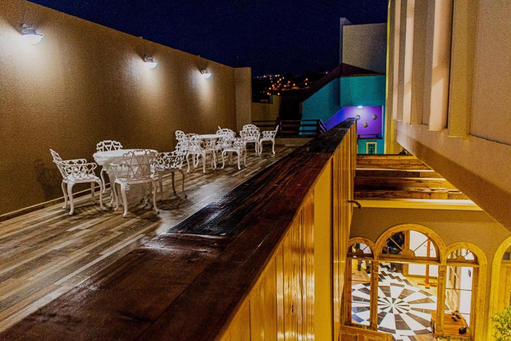 拉塞雷納的住宿－Hotel Boutique Suri，阳台的酒吧配有白色的椅子和桌子