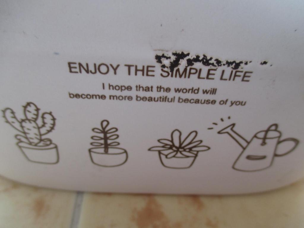 una taza con plantas en ella con las palabras disfruta de la vida simple en António Augusto Apartment, en Coímbra
