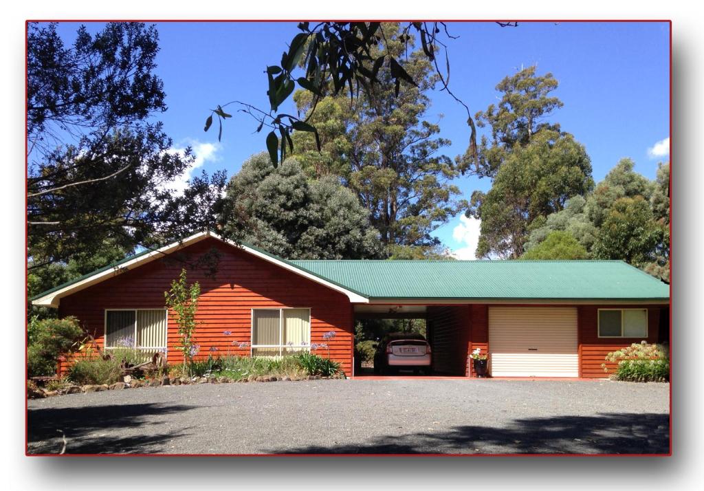 a red house with a green roof and a driveway at Acacia Hills Retreat in Acacia Hills