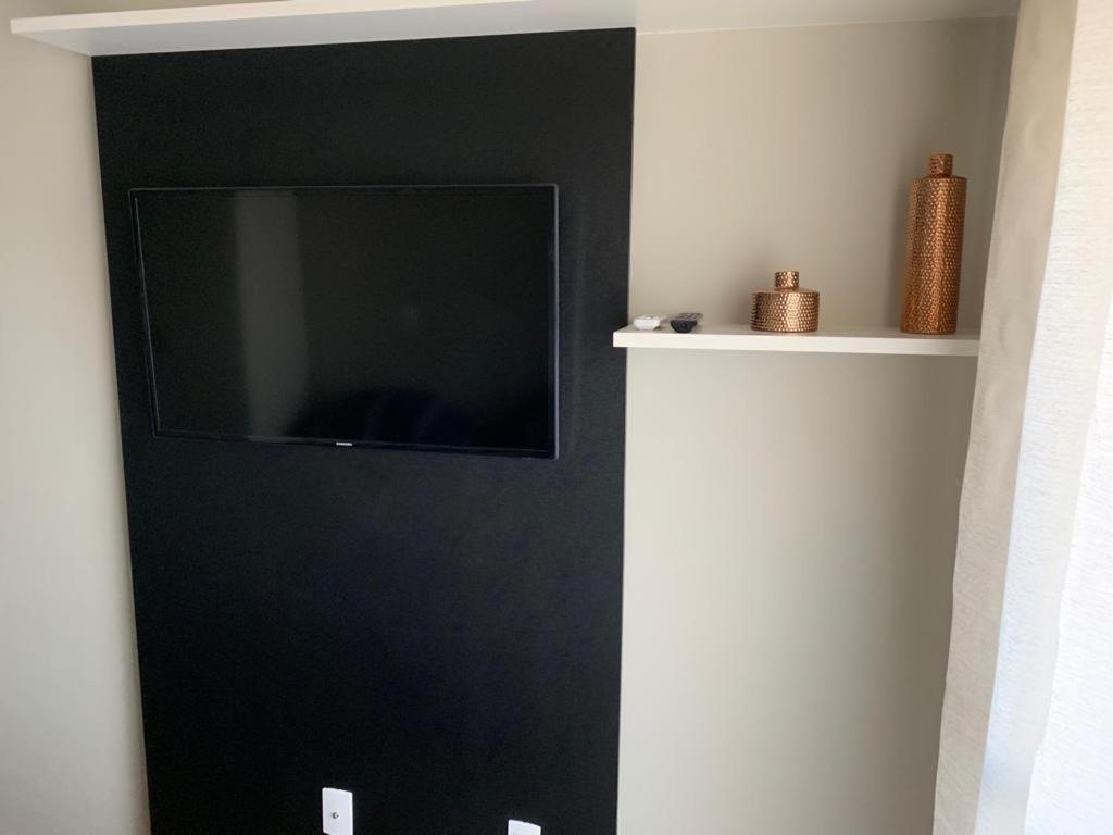 a flat screen tv on a wall in a room at Flat Granja Viana in Cotia