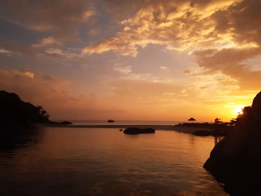 a sunset over a river with an elephant in the water at Nangyuan Island Dive Resort in Ko Tao