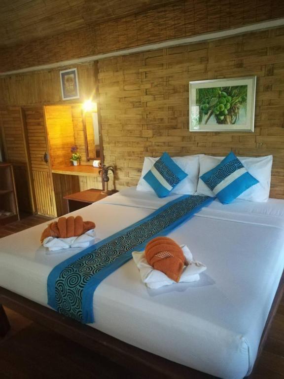 a bedroom with a large white bed with blue pillows at Nangyuan Island Dive Resort in Ko Tao