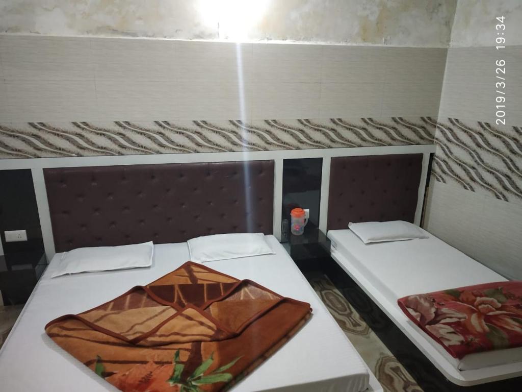 Postel nebo postele na pokoji v ubytování Vidya Guest House