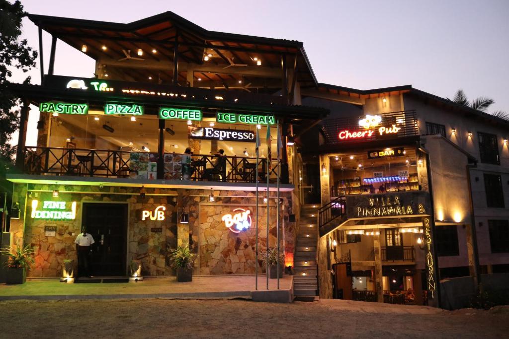 ピンナワラにあるヴィラ　ピナワラ＆レストランの横にネオンの看板が立つ建物