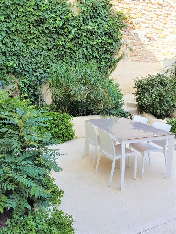 a white table and chairs in a garden at L&#39;Accent d&#39;ici in Le Somail