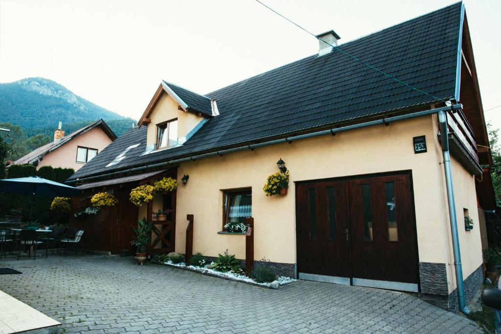 dom z czarnym dachem i garażem w obiekcie Vilka Tkáč w mieście Kwaczany