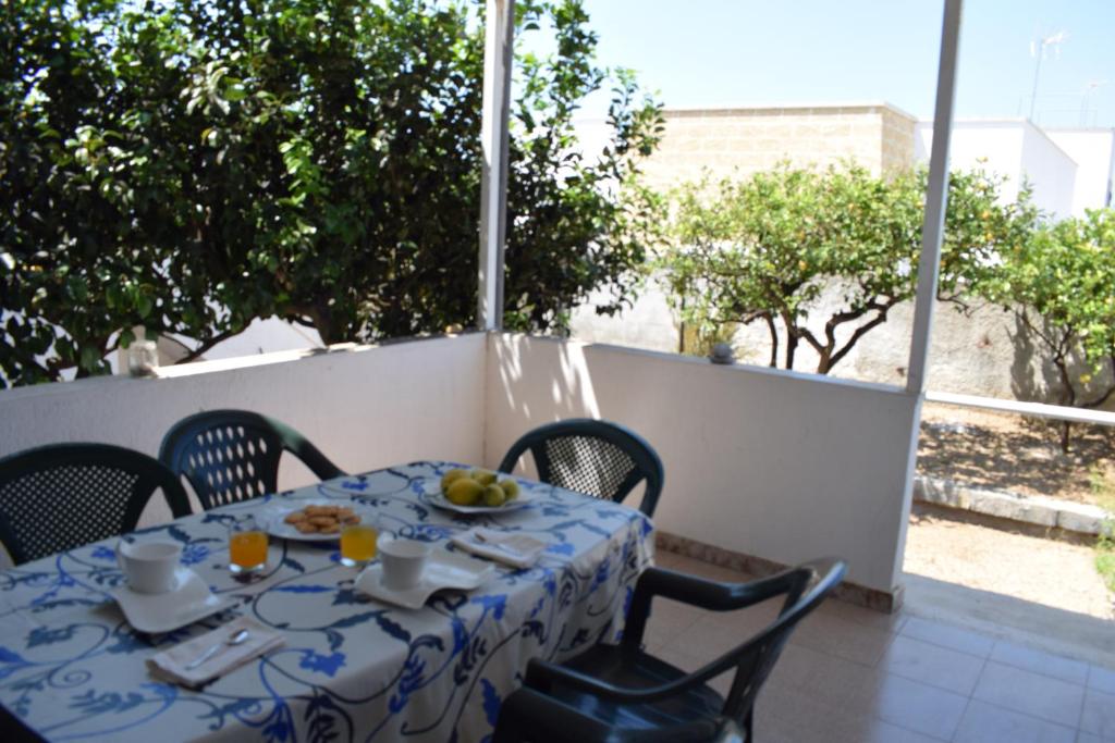 マリーナ・ディ・マンカヴェルサにあるAlba Chiara - Villa con Giardinoのバルコニーにテーブル(青と白のテーブルクロス付)