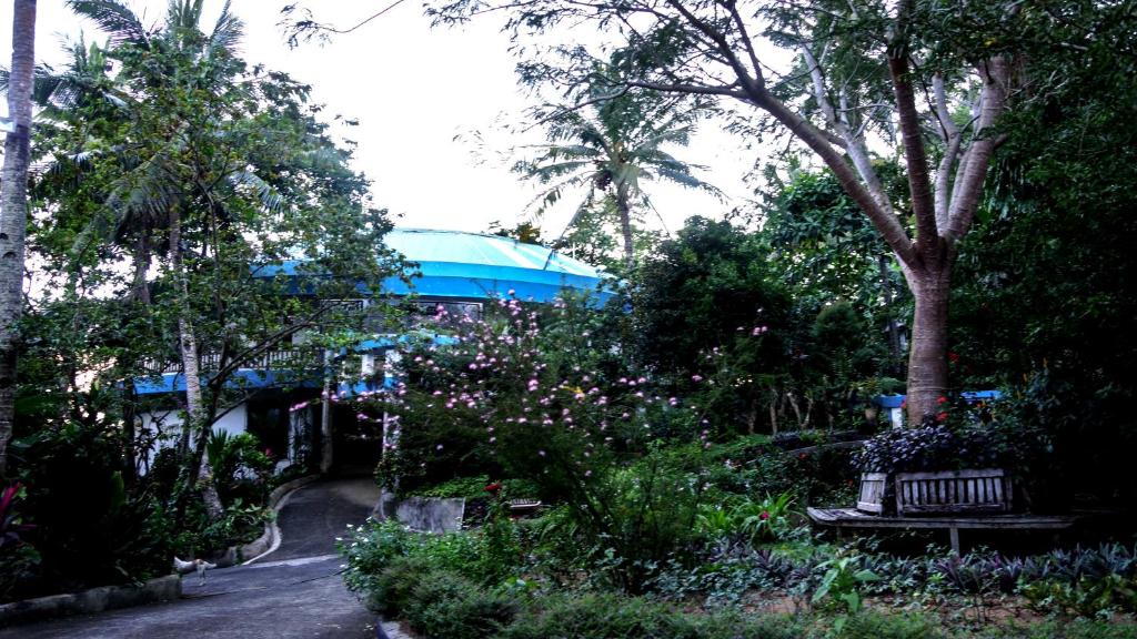 un parc avec un banc, des arbres et des fleurs dans l'établissement Mirisbiris Garden and Nature Center, à Santo Domingo