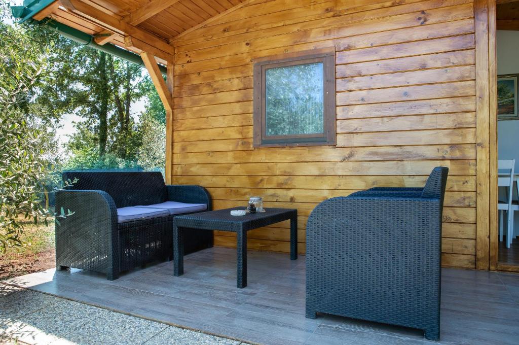 a patio with two chairs and a table and a window at Eco Holiday Home Lavanda in Funtana