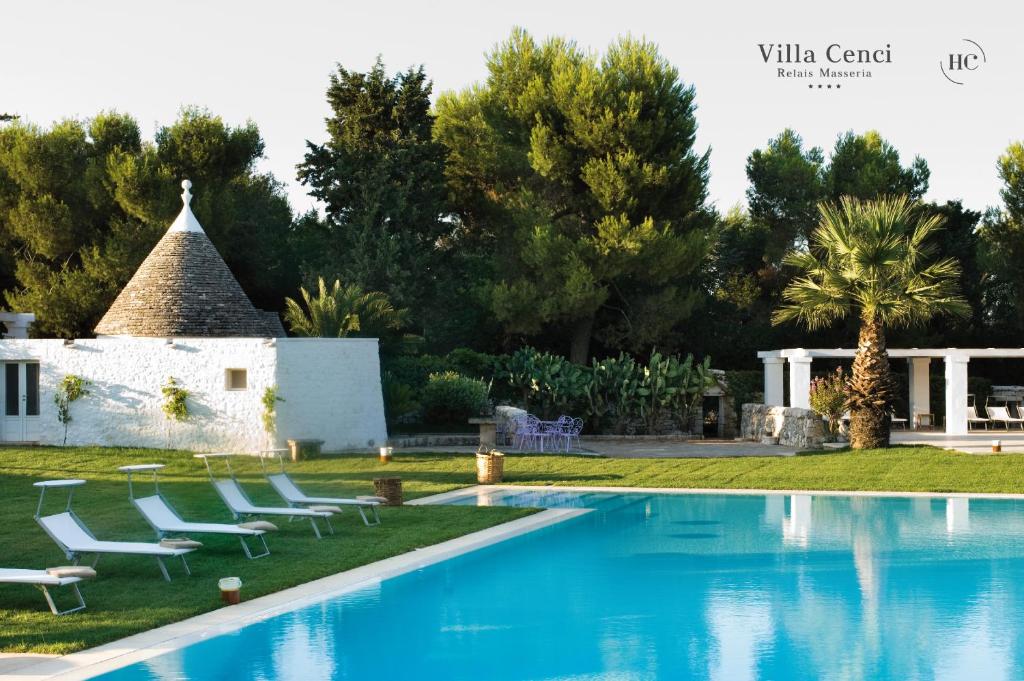 une villa avec une piscine et une maison dans l'établissement Relais Masseria Villa Cenci, à Cisternino