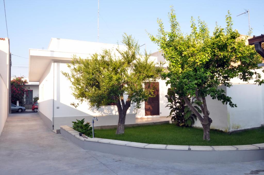 two trees in front of a white house at Casa Vacanze Eufemia in Giurdignano