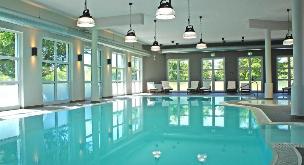 a large swimming pool in a building with windows at Feriendorf am Bakenberg in Dranske