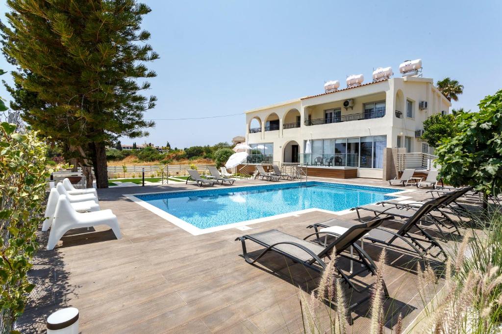 a villa with a swimming pool and a house at Sea Breeze Apartments - 3 Bedroom Apartment in Peyia