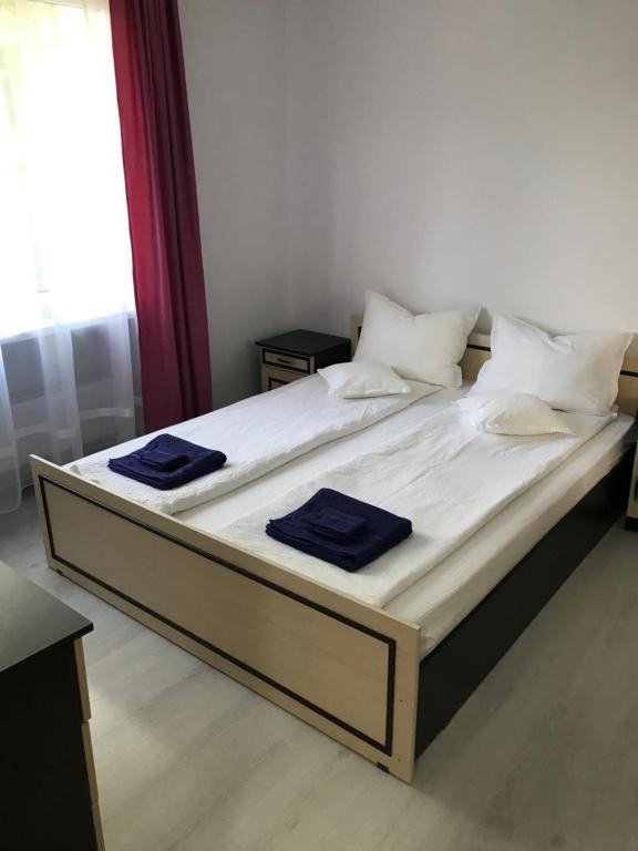 a large bed with white sheets and blue towels on it at Town Centre Flat in Blaj