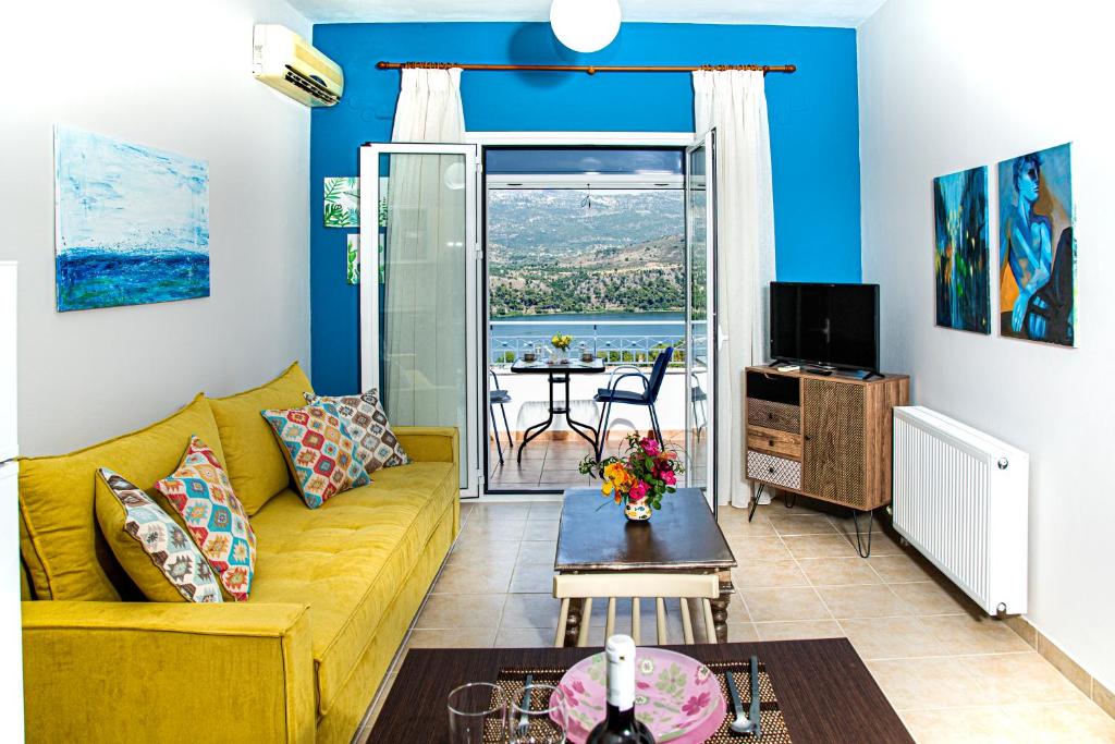 a living room with a yellow couch and a table at Antigone Apartments Argostoli (Spilia) 4 in Argostoli