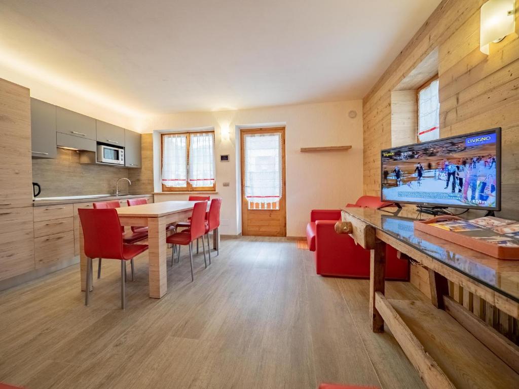 eine Küche und ein Esszimmer mit einem Tisch und einem TV in der Unterkunft Leveron Apartments in Livigno