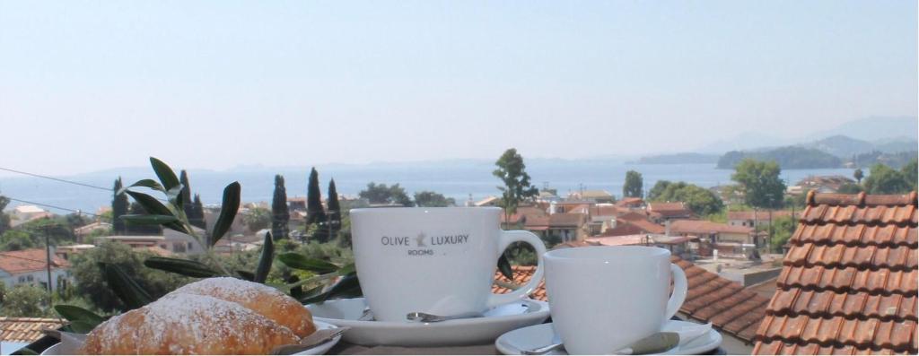 two cups of coffee and donuts on a table at Olive Luxury Rooms in Ipsos