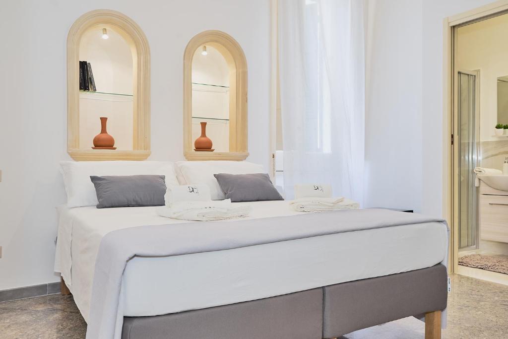 una camera bianca con un grande letto bianco di Dimora Casanello a Lecce