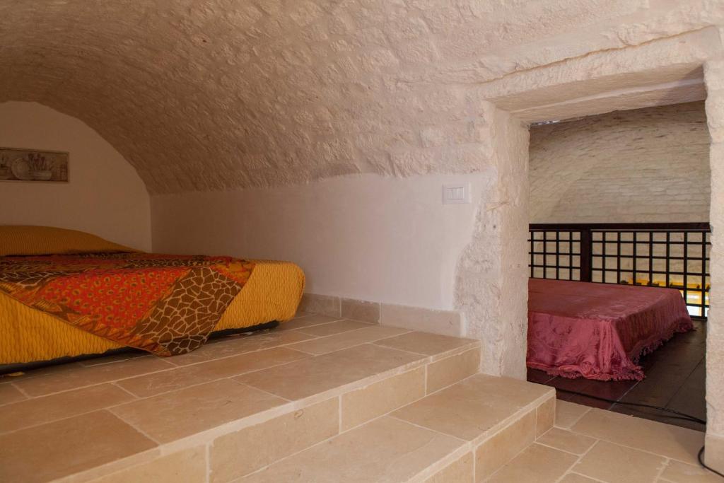 1 dormitorio con 2 camas y pared de ladrillo en Da Santino, en Alberobello