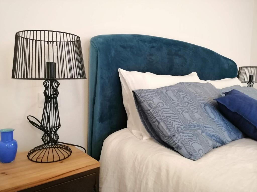 łóżko z niebieskim zagłówkiem i lampką na stole w obiekcie Stefany's Home Venice Apartment w Wenecji