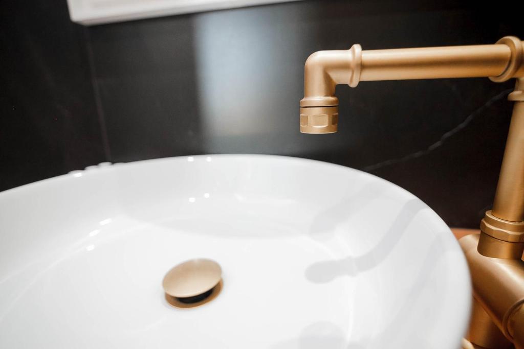 a close up of a white sink with a faucet at Golden Bay Suites & Maisonettes in Parga