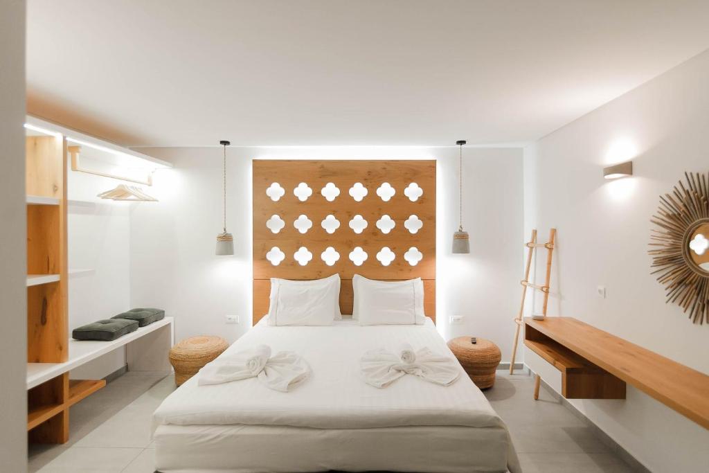 a bedroom with a large white bed with white sheets at Golden Bay Suites & Maisonettes in Parga