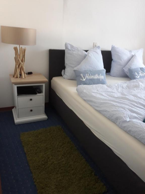ein Schlafzimmer mit einem Bett und einem Nachttisch mit einer Lampe in der Unterkunft Rathausschenke Münstermaifeld in Münstermaifeld