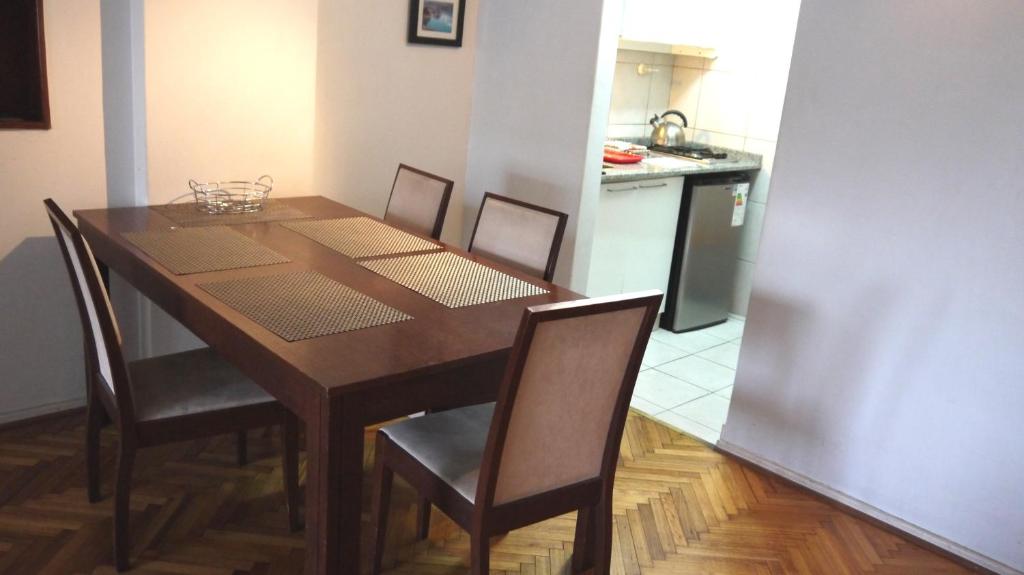 a dining room table with chairs and a kitchen at Obelisco Studio 9 in Buenos Aires