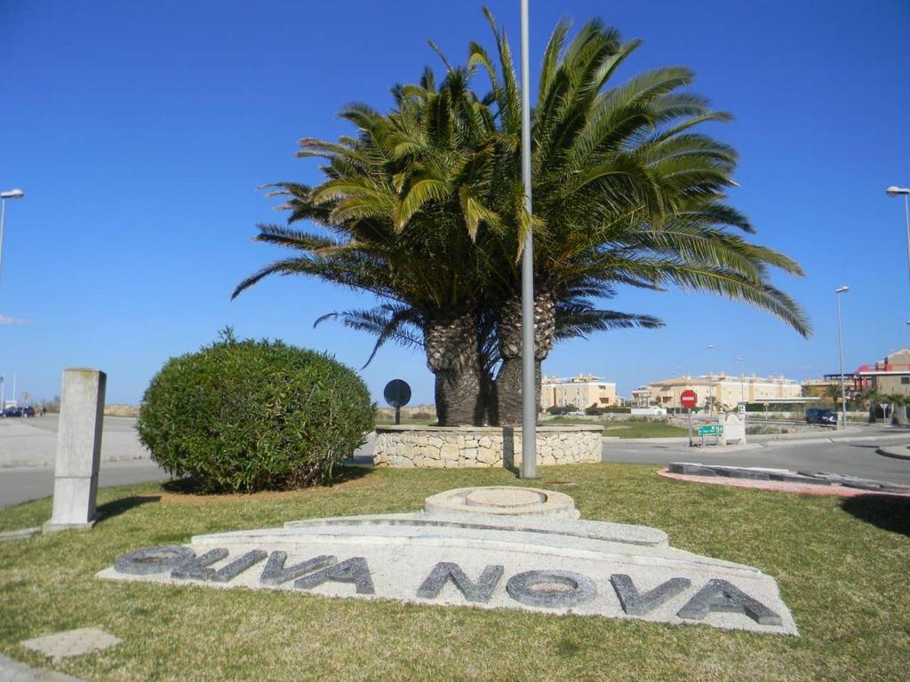 ein Schild im Gras mit einer Palme in der Unterkunft Oliva Nova Golf in Oliva