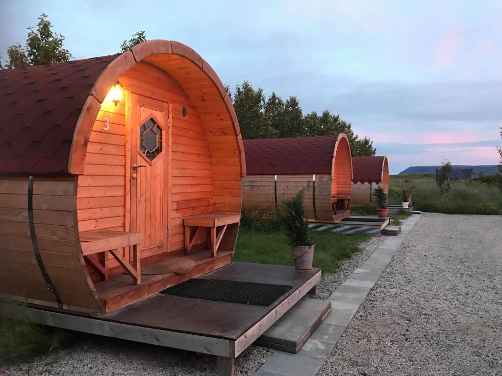 a small wooden cabin with a bench in the yard at Ásahraun Guesthouse in Selfoss